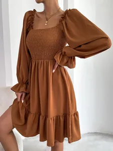 Gedetailleerde weergave van jurk met vierkante hals en gesmokt lijfje in terracotta