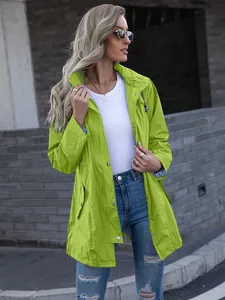 Detailed front view of a women's lime green hooded mid-length raincoat in an urban setting.