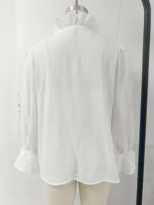 Detailed back view of an elegant white linen blouse with romantic ruffled collar