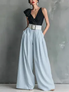 Ganzkörperaufnahme einer hellblauen weiten Hose kombiniert mit einem schwarzen Top mit V-Ausschnitt