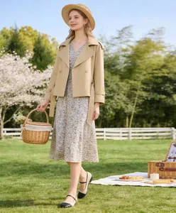 Elegant short beige trench coat jacket with lapel and belt shown in a spring picnic scene.