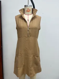 Detalle de un vestido de lino marrón sin mangas con cuello alto y cremallera frontal.