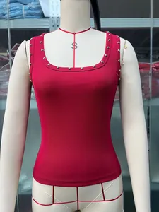 Detailansicht eines roten gerippten Tanktops mit silbernen Nieten auf einer Schneiderpuppe