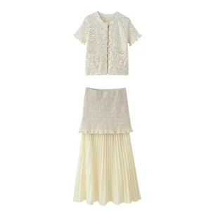Gedetailleerde weergave van een elegante crème gebreide top en geplooide maxi-rok tweedelige set