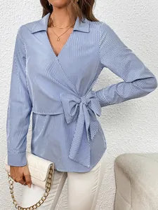 Detail of a blue and white striped long-sleeve blouse with a wrap v-neck and side bow tie.