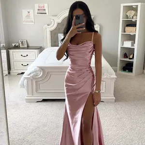 Elegant pink satin gown dress with sexy ruched detail and high slit in bedroom setting