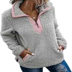 Détail d'un sweat-shirt en polaire grise avec des accents de fermeture rose