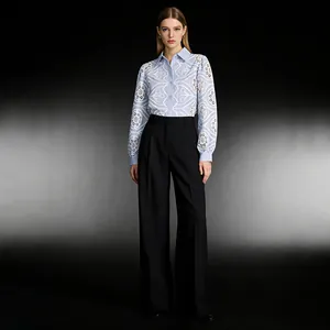 Professional detail view of a light blue embroidered cutout shirt and black wide-leg trousers.