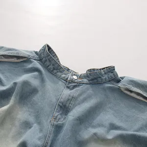 Détail du jean denim délavé taille haute avec découpe irrégulière au niveau de la taille