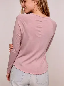 Détail de la vue arrière d'un t-shirt rose à manches raglan et bordure ondulée