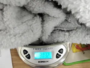 Detailed weight measurement of the grey double-sided fleece lounge set at 303.2 grams