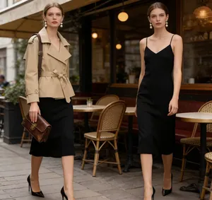 Stylish short khaki trench coat with belt styled over a black midi slip dress outdoors.