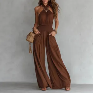 Close-up detail of smocked waist and pockets on a brown bohemian wide-leg jumpsuit