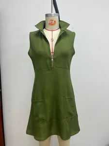 Detalle de un vestido de lino sin mangas verde oliva con cremallera frontal y bolsillos.