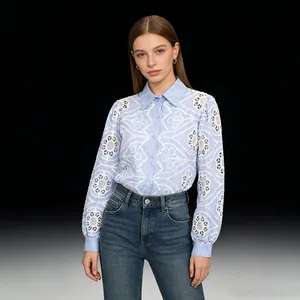 Close-up detail of a blue striped shirt with intricate white lace embroidery and hollow cutouts
