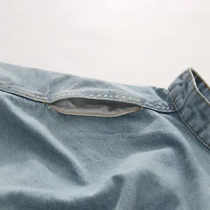 Détail rapproché de la découpe irrégulière d'un jean bleu clair à taille haute