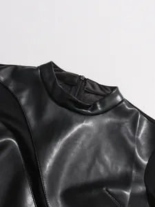 Dettaglio ravvicinato della maglia nera in ecopelle patchwork con texture e scollatura