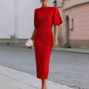 Elegante abito midi rosso con vita aderente e maniche ampie su uno sfondo urbano.