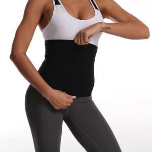 Donna indossa una fascia addominale nera con reggiseno sportivo bianco in palestra
