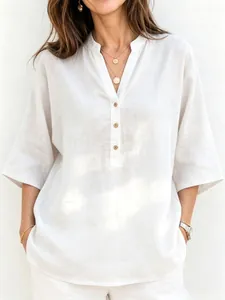 Detalle de camisa de lino blanco con cuello mao, escote en V y botones de madera