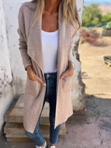 Detail view of women's long beige knit cardigan with open front and functional pockets