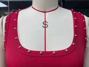 Nahaufnahme eines roten gerippten Tanktops mit silbernen Nietenverzierung am Ausschnitt.
