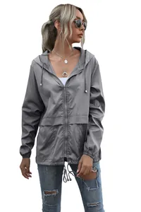 Full-length view of a women's lightweight grey hooded zip-up hiking rain jacket