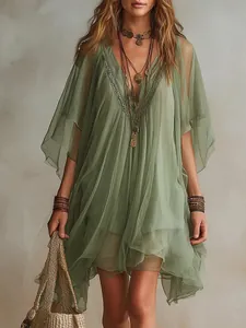 Nahaufnahme eines grünen Boho-Chiffonkleids mit V-Ausschnitt und zarten Spitzendetails.