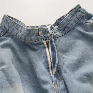 Gros plan sur la taille et la fermeture éclair en métal d'un jean vintage à taille haute