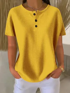 Close-up of yellow waffle-knit Henley shirt featuring front buttons and soft textured fabric.