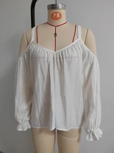 Nahaufnahme der weißen schulterfreien Bluse mit Rüschenmanschetten an einer Puppe.