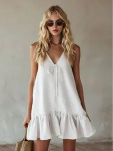 Elegant white V-neck sleeveless ruffle dress with a bow tie detail for retro summer vacations.