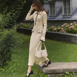 Elegant French-style cream knit midi dress with contrast trim in outdoor garden setting