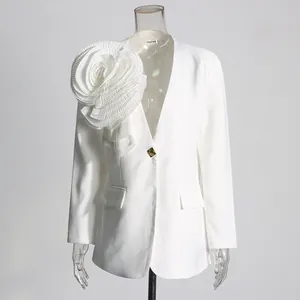 Detail of white women's blazer with a large 3D pleated fabric flower on the shoulder.