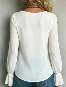 Rear view of an elegant white pleated long-sleeve blouse featuring stylish ruffled cuffs