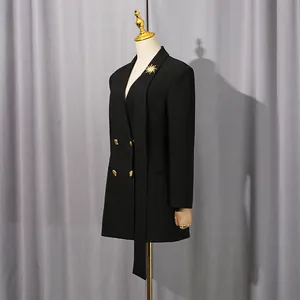 Blazer noir chic à double boutonnage avec broche soleil, vue de côté sur un mannequin.