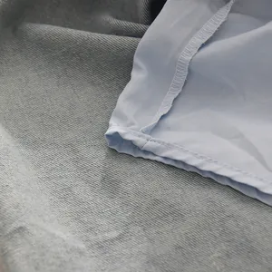 Détail de la doublure intérieure et des coutures surjeteuses précises sur un jean en denim bleu