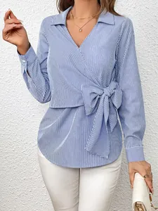 Detailed shot of a blue and white striped wrap blouse featuring an elegant side bow knot