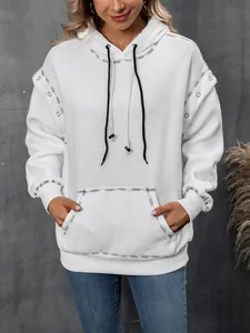 Detailed view of white oversized hoodie with metal eyelet sleeves and drawstring.