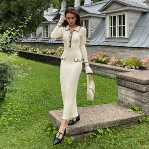 Detailed view of elegant cream knit dress with contrast black trim and ruffled cuffs.