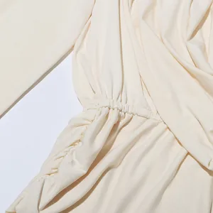 Vue détaillée de la taille froncée sur un chemisier d'été minimaliste de couleur crème.