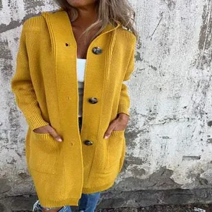 Dettaglio di un cardigan lungo in maglia giallo senape con cappuccio e grandi bottoni