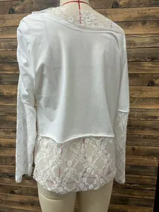 Close-up of white off-shoulder T-shirt featuring delicate lace sleeves and hem details