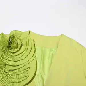 Detail view of lime green blazer featuring a large 3D pleated fabric flower