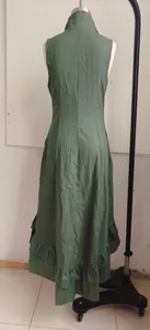 Close-up back view of a dark green vintage sleeveless dress featuring a ruffled hemline