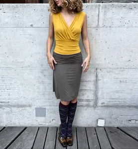 Close-up detail of a yellow V-neck pleated slimming tank top worn by a model outdoor