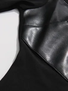 Vista dettagliata del patchwork in ecopelle testurizzata su un top nero slim da donna.
