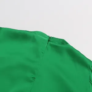 Macro shot of back neckline featuring hidden zipper on elegant green satin shirt detail