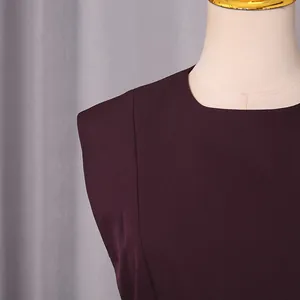 Gros plan sur l'encolure d'un chemisier bordeaux élégant sur un mannequin de couture