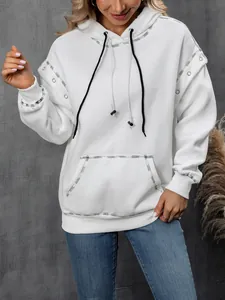 Detailed view of white hooded sweatshirt with contrast black stitching and drawstrings.